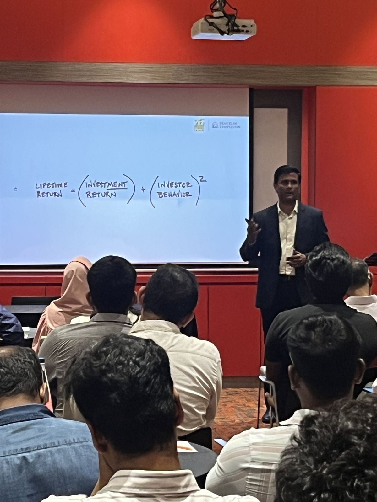 Speaker explaining Lifetime Return formula