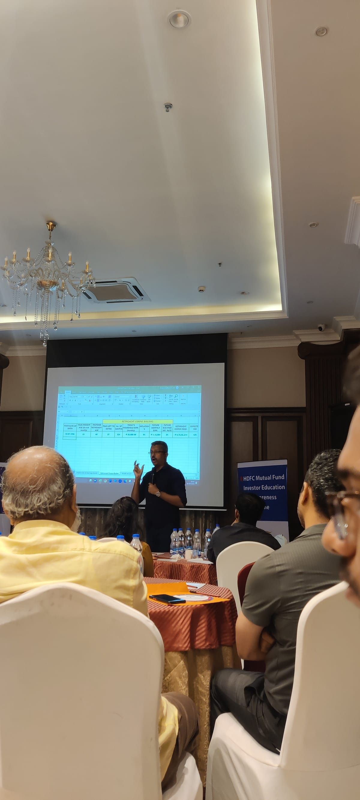 Speaker presenting with audience in foreground